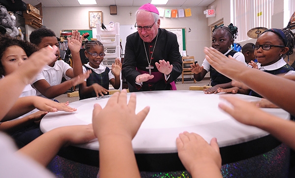 Bishop Richard Malone joins the drum circle in music class on the first day of school with St. Joseph University School students on Main Street, Buffalo. (Dan Cappellazzo/Staff Photographer)